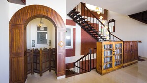 Un escalier avec une rampe en bois et une porte en verre en bas.