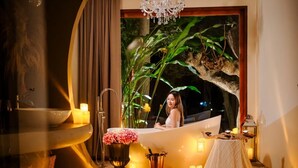 A woman in a bathtub with candles, a plant, and a chandelier. - Hatchu khaoyai (Pak Chong)
