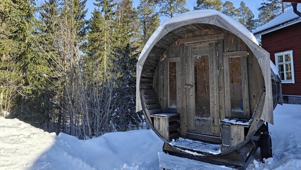 A wooden log cabin with a large, round, snow-covered entrance. - Norrkällan (Vännäs)