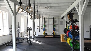 A gym with weightlifting equipment, a bench, and a rack of weights. - Norrkällan (Vännäs)