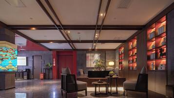 A lobby with a reception desk, seating area, and shelves with items.