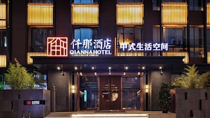 Entrada de hotel con letreros iluminados, fachada moderna y vista despejada de las puertas de acceso.