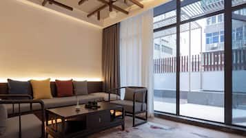 シグネチャー ダブルルーム クイーンベッド 1 台 専用バスルーム コートヤードビュー | リビング エリア