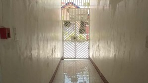 A corridor with a tiled floor leading to a gated entrance.