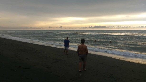 A beach with a clear sky and calm sea, suitable for relaxation.
