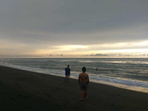 A beach with a clear sky and calm sea, suitable for relaxation.