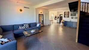 A spacious living area with a sofa, a coffee table, and a staircase. - House with pool and jacuzzi in Cagnes-sur-Mer (Cagnes-sur-Mer)