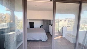 A bedroom with a bed, a small bedside table, and a window with a view of buildings. - House with pool and jacuzzi in Cagnes-sur-Mer (Cagnes-sur-Mer)
