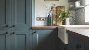 A kitchen with teal cabinets, a wooden countertop, a white sink, and a plant. - Luxury Golf House near Royal Birkdale (The Open) | Hot Tub | Sleeps 12+ (Southport)