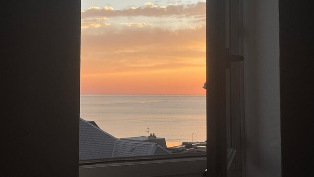 Udsigt gennem et vindue med klar himmel og et fjerntliggende horisont.