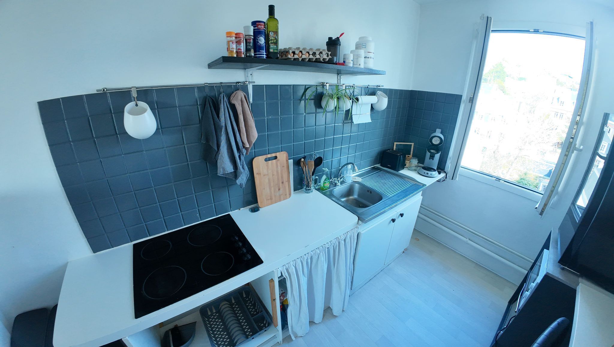Eine moderne Küche mit Herd, Spüle und Fenster.