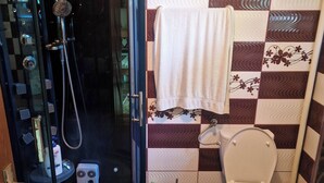 Ein Badezimmer mit Dusche, Toilette und einer Wand mit Muster.