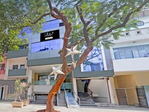 Un edificio moderno con una scala che conduce all'ingresso, un albero decorato e un cartello che indica un servizio aziendale.