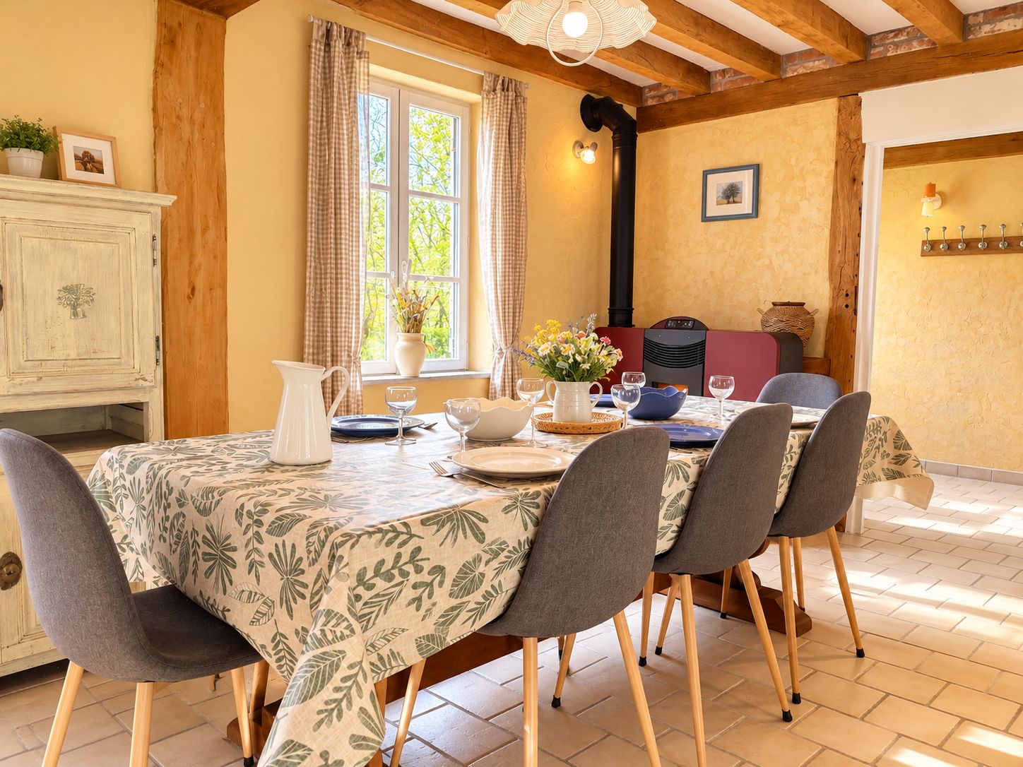 Comedor con una mesa dispuesta para cuatro personas, rodeado de sillas.