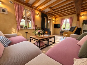 Un salon chaleureux avec une cheminée, des fauteuils confortables et un téléviseur.