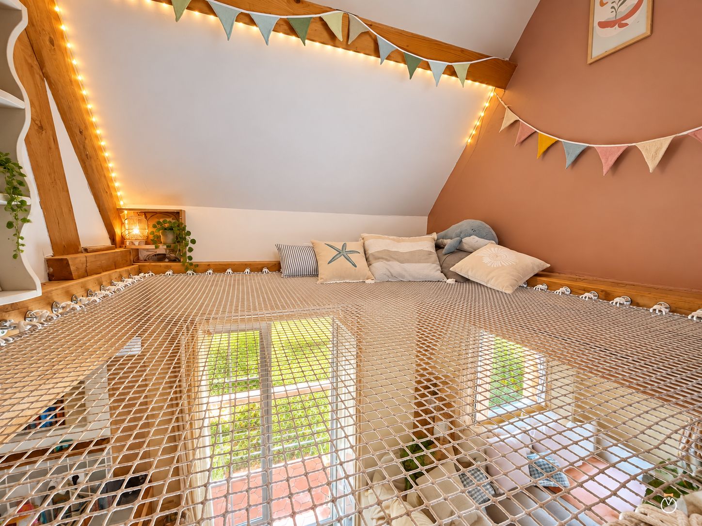 Una habitación acogedora con mosquitero, vigas de madera y luces colgantes.