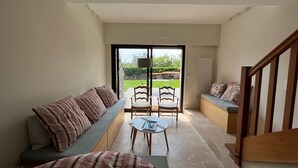 A modern interior with a sofa, chairs, and a staircase. - 3 bedroom house and garden facing the beach. Arzon. Gulf of Morbihan (Arzon)
