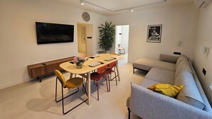 A modern living room with a dining area, a sofa, a TV, and a plant. - Modern vacation apartment in Crikvenica with internet, sea view, barbecue (Crikvenica)