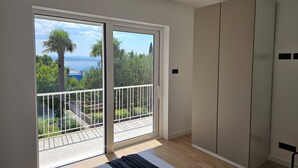 A bedroom with a large sliding glass door leading to a balcony, a bed, and a wardrobe. - Modern vacation apartment in Crikvenica with internet, sea view, barbecue (Crikvenica)