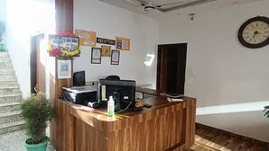 A reception desk with a wooden finish, a clock on the wall, and a staircase leading to an upper level. - Collection O Lansdowne Viewpoint (Lansdowne)