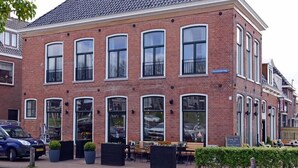 Een gebouw van baksteen met grote ramen en een plat dak.