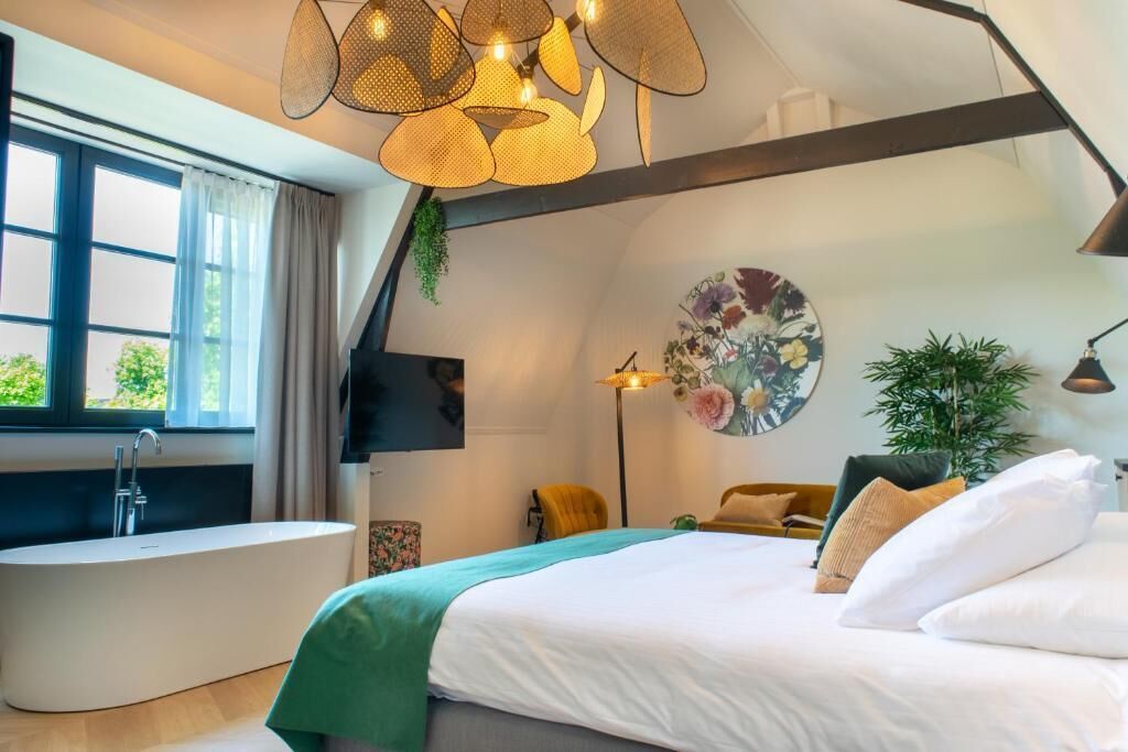 Una camera da letto moderna con un letto grande, una vasca da bagno e un'ampia finestra.