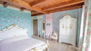 Ein Schlafzimmer mit Bett, Schminktisch, Stuhl und Spiegel.