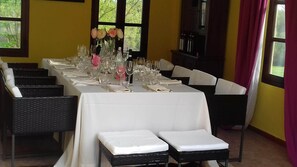 A dining table set for a meal with chairs, a vase with flowers, and bottles on the table. - Villa Piemonte - Romantik Country House in the Piedmont Vineyards (Cà Mogna)