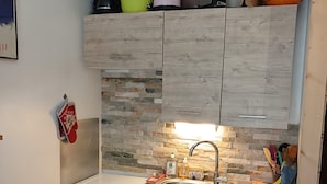 A compact kitchen with a built-in oven, a sink, and a small refrigerator. - Praloup 1600 Studio ground floor with exterior (Uvernet-Fours)