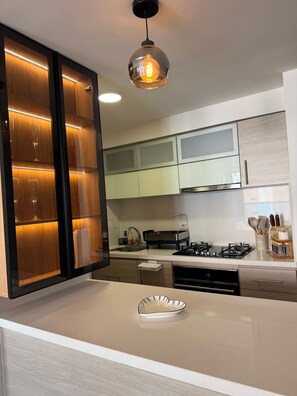 A modern kitchen with a central island, stainless steel appliances, and a pendant light. - Luxurious 3-bedroom Apartment in Piedecuesta, Colombia (Piedecuesta)