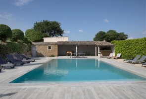 Una piscina al aire libre de temporada, sombrillas