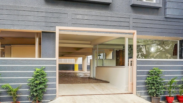 A building entrance with a glass door, potted plants, and a tiled floor. - Deluxe Hebbal Townhouse (Bengaluru)