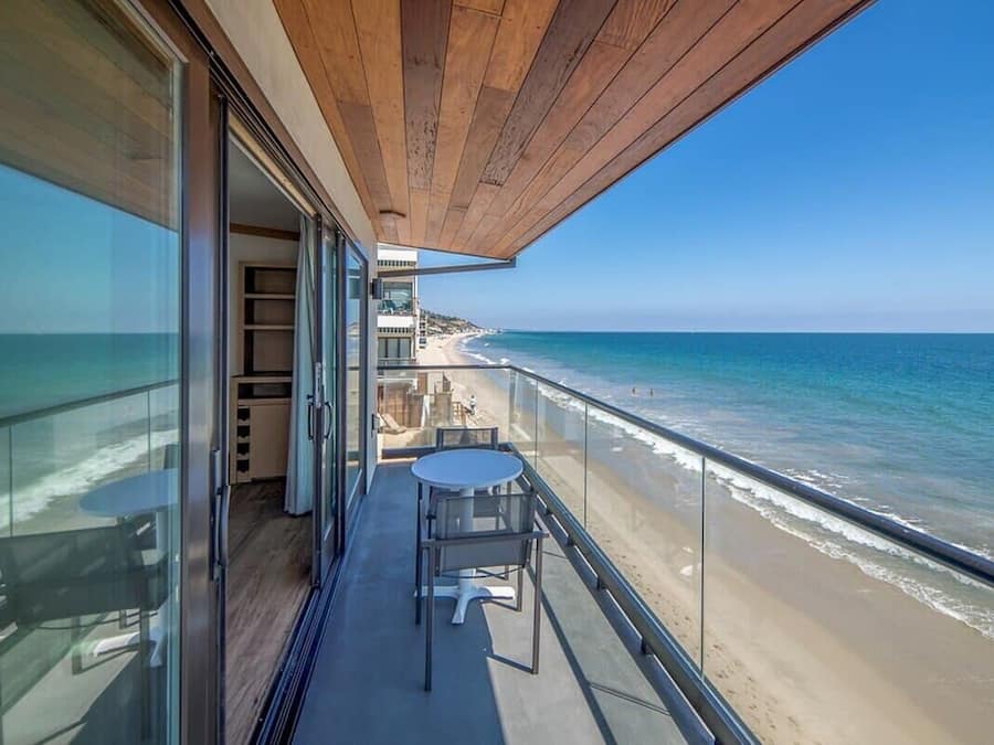 A balcony with a view of the beach and ocean.