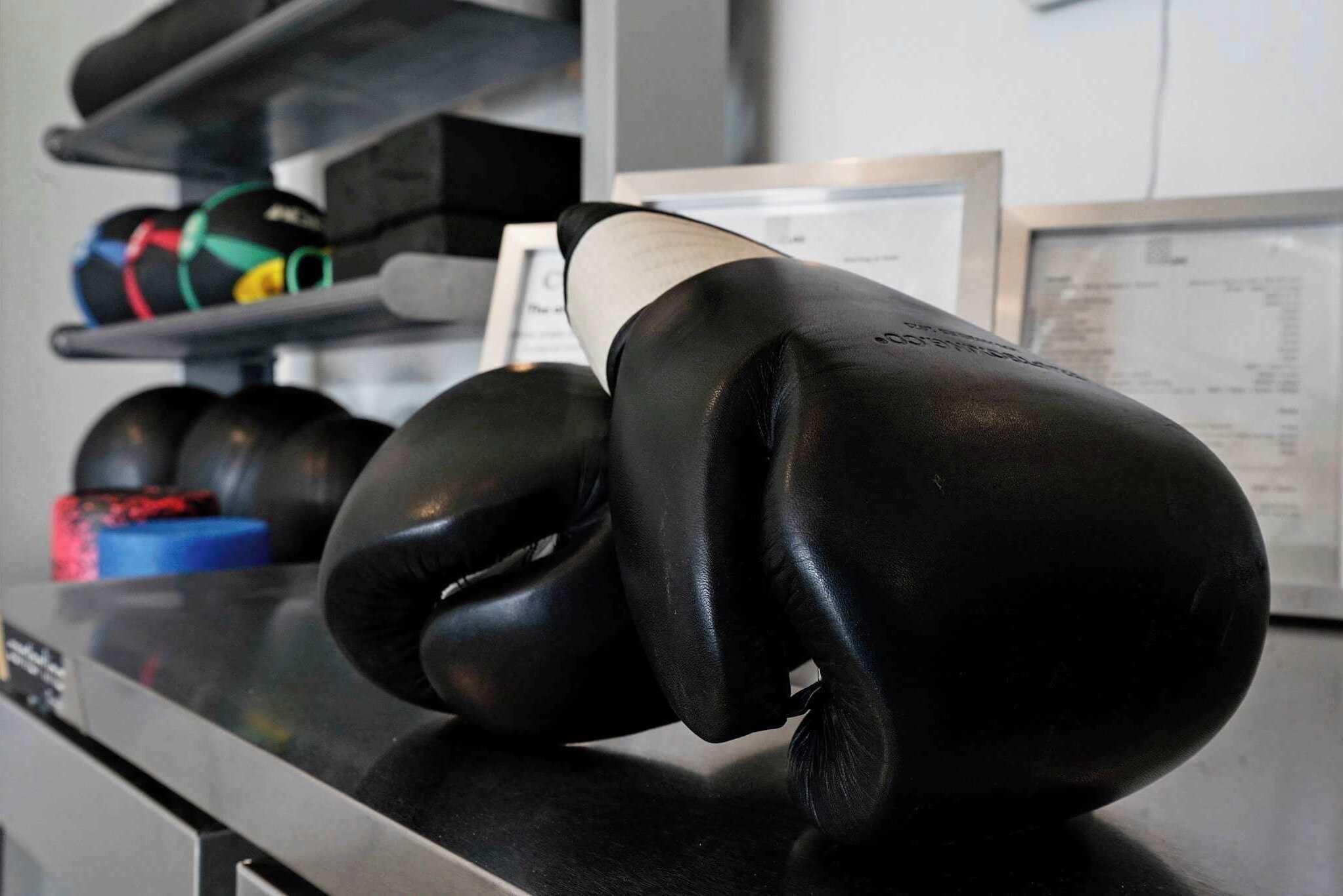 A pair of black boxing gloves on a counter.