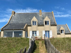 A two-story house with a steep roof, large windows, and a wooden fence in front. - Family house, direct beach access - 9 guests (Batz-sur-Mer)