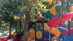 A playground with slides and a clock. - Cozy chalet with terrace - 5 guests (Algajola)