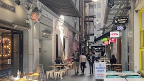 A narrow alley with outdoor seating, a barber shop, and a pizza place. - The Heritage Bank Apartment (Melbourne)
