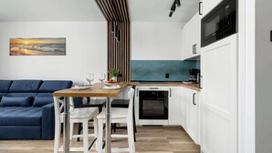 Eine moderne Küche mit weißen Schränken, einer Holz Arbeitsplatte und einem eingebauten Backofen.