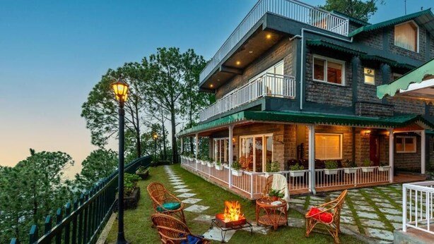 A two-story house with a balcony, outdoor seating, and a fire pit. - ELIVAAS Fleur De Lis 4 BHK Villa (Kasauli)
