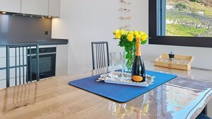 A modern kitchen with a dining area, a bottle of wine, and a view of a vineyard. - Lovely apartment for 2 people with WIFI, TV and panoramic view (Riazzino)
