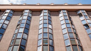 Ein Gebäude mit vielen Fenstern und einer flachen Dachfläche.