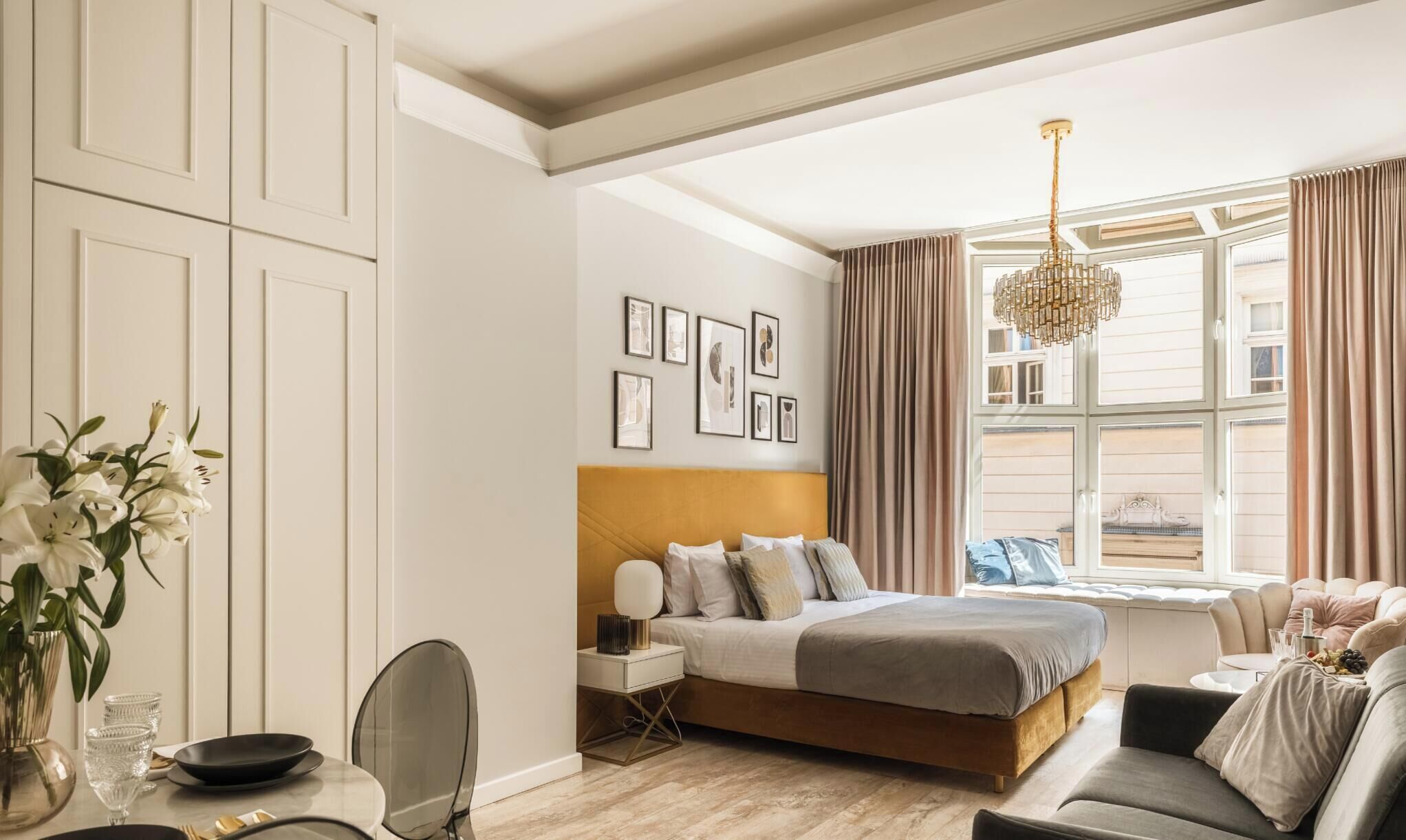 Una camera da letto con un letto, un comodino, una lampada e una finestra con tende.