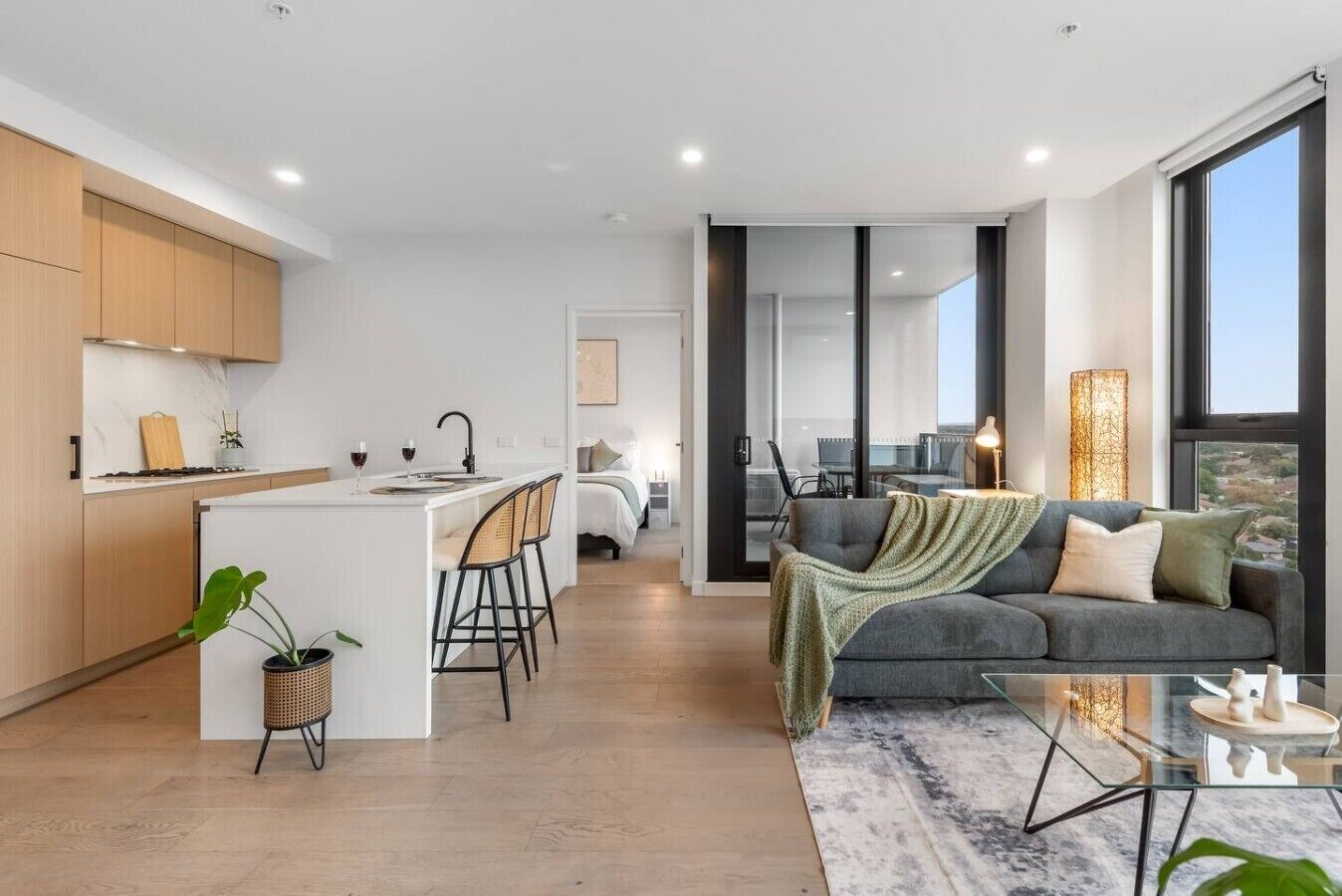 A modern apartment with a kitchen, dining area, and living room.