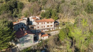 Un edificio de piedra con varios pisos, rodeado de árboles.