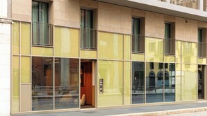 A modern building with large glass windows, a visible entrance, and a number '48' on the door. - Bob W Milan Crocetta (Milan)