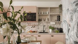 A kitchen with a microwave, sink, and various kitchenware on shelves. - Grodzka Corner Apartments — Senacka 11 — Kraków Old Town — by Luvaro (Kraków)