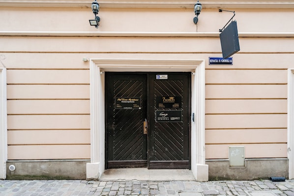 Un edificio con due porte nere, un cartello sopra le porte e una piccola finestra sul lato destro.