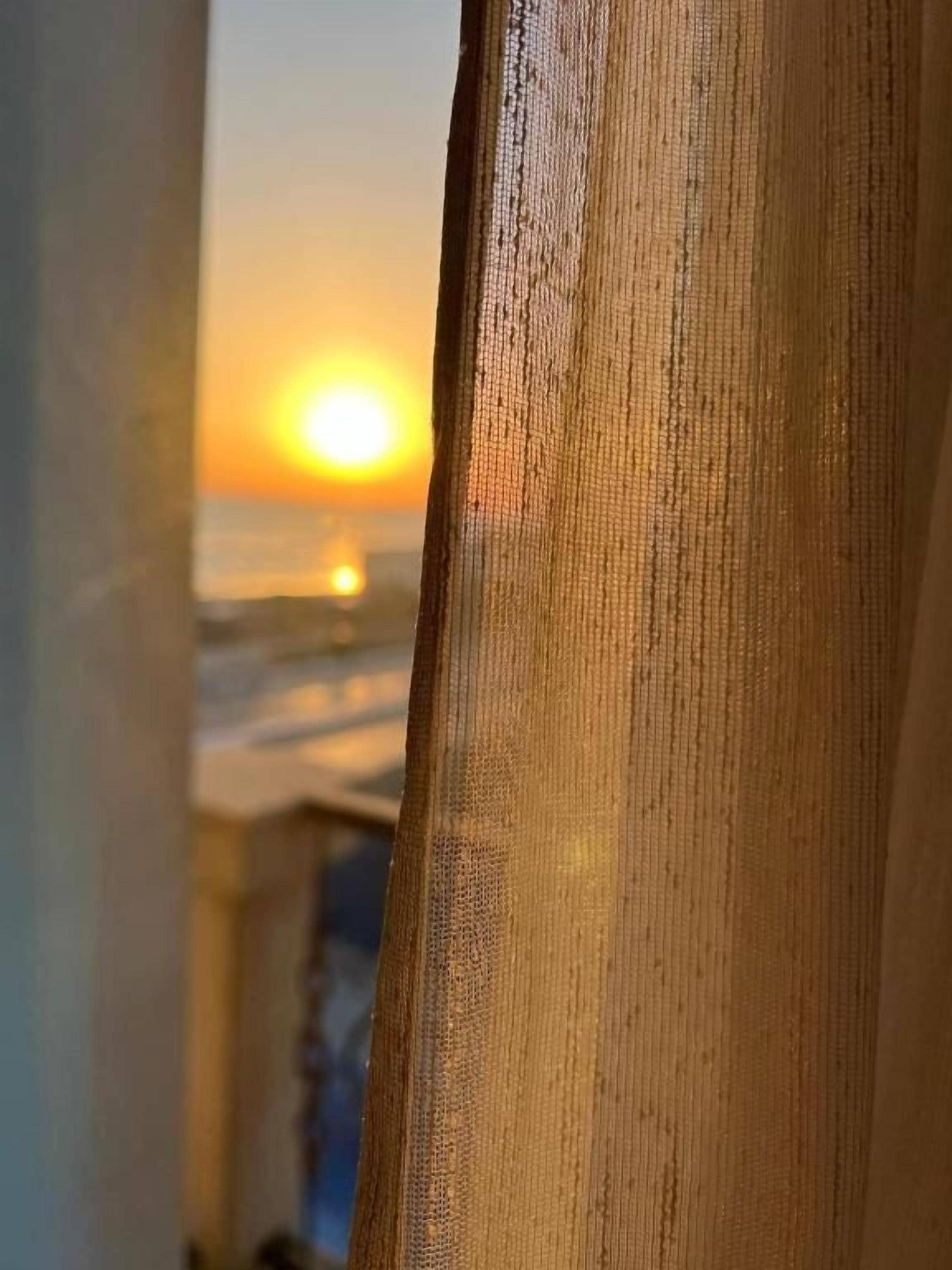 A wooden structure with a view of the sunset over the ocean.