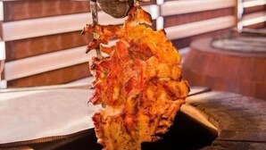 A hand holding a large, grilled pineapple. - Gallery & Sea Hotel (Sumqayit)