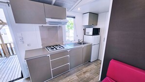 Una cocina compacta con estufa a gas, microondas y refrigerador.